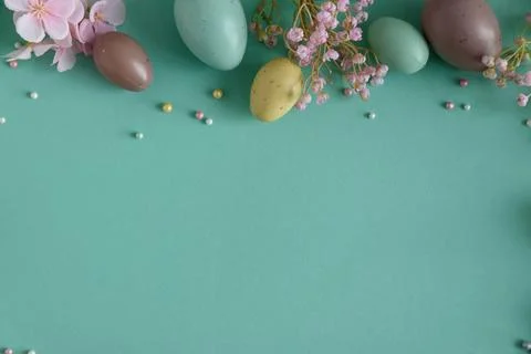 Pastel Easter Eggs and Flowers on Teal Background. Festive Spring Flatlay Stock Photos