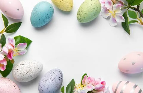 Pastel easter eggs and pink blossoms creating spring border Stock Photos