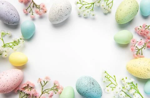Pastel easter eggs and spring flowers creating border Stock Photos