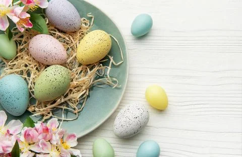 Pastel easter eggs arranged on rustic plate Foto stock