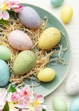 Pastel easter eggs arranged on rustic plate Foto stock