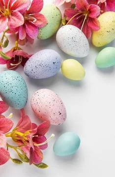 Pastel easter eggs with speckles and spring flowers Stock Photos