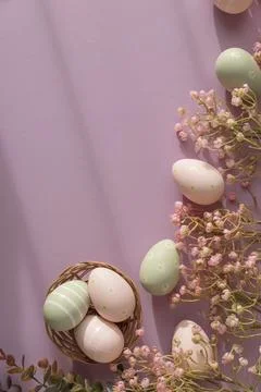 Pastel Easter Eggs in Wicker Basket with Flowers on Pink Background Stock Photos