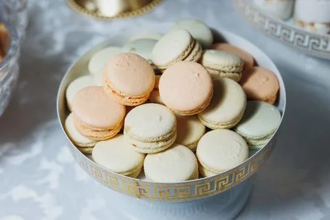 Pastel macarons nestled in elegant, patterned bowl 스톡 사진
