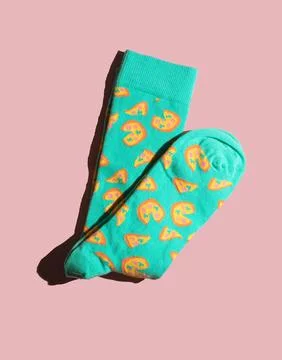 Pastel patterned colourful sock folded in half on pink background. Minimali.. Stock Photos