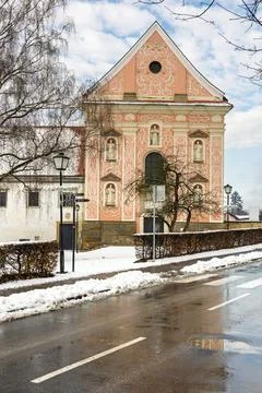 Pastel Pink Dominican monastery Facade With Ornate Details, Snowy Street Sc.. Stock Photos