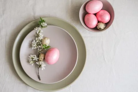 Pastel pink Easter eggs in gray plate on linen tablecloth. Easter table set.. Stock Photos
