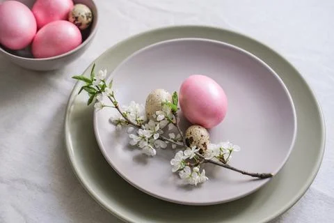 Pastel pink Easter eggs in gray plate on table with linen tablecloth. Delicat Stock Photos