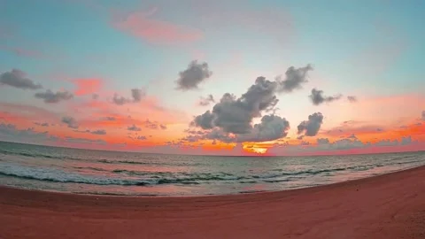 Pastel pink sunset cloud over sea water n ocean wave on autumn beach Stock Footage 160644388
