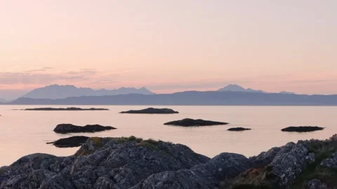 Pastel pink sunset over misty mountains and calm Scottish sea Stock Footage 335540153