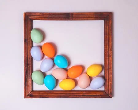 Pastel scattered Easter eggs framed on pink Stock Photos