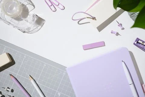 Pastel workspace flat lay with notebook, pen, tape, pins and stationery on wh Stock-Fotos