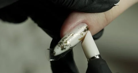 Pasting a pattern on a nail in a beauty salon. the master does a manicure Stock Footage 234197018