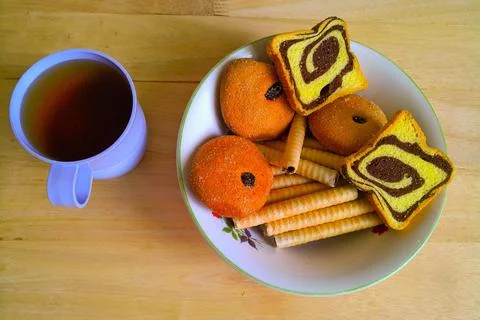 Pastries and bread biscuits and also rolled biscuits in a bowl and also tea Stock-Fotos