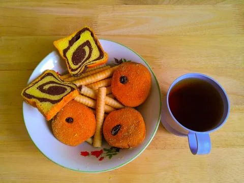 Pastries and bread biscuits and also rolled biscuits in a bowl and also tea Fotos Stock