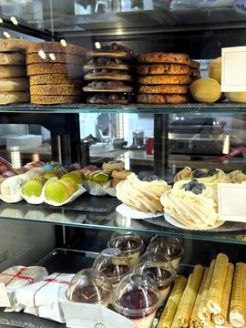 Pastries and Sweets Displayed in an Inviting Cafe Setting During a Busy Morni Stock Photos