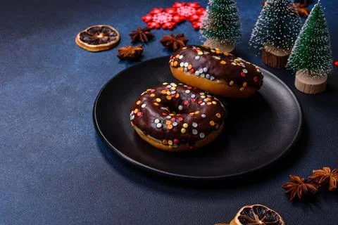 Pastries concept. Donuts with chocolate glaze with sprinkles, on a dark concr Stock Photos
