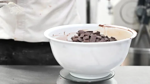 Pastry Chef adding chocolate pieces ready to melt. Ingredientes of the recipe of Stock Footage 138236158