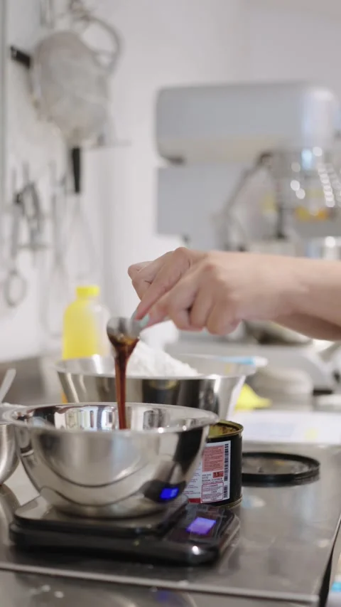 Pastry chef adding dates syrup in a bowl on kitchen scale Stock Footage 314002460