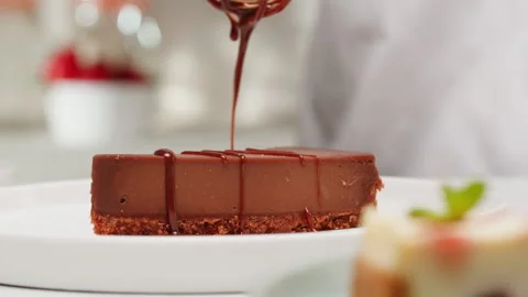 Pastry chef adding liquid chocolate topping on chocolate dessert cheesecake Stock-Footage 279187115