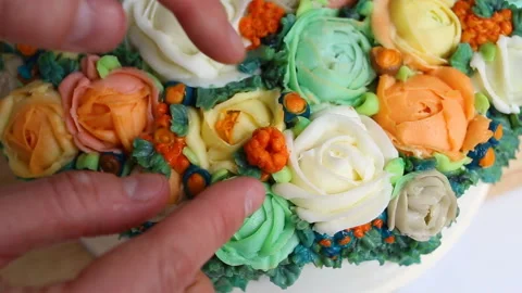 The pastry chef adjusts a bright orange berry. Bright elegant cake decorated wit Stock Footage 143730736