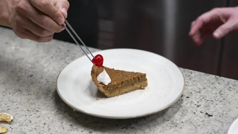 The pastry chef and his apprentice prepares recipe for a slice of pumpkin Stock Footage 263806523