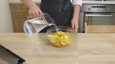 A pastry chef in apron cools sliced ​​oranges in a bright kitchen Video stock 231240239