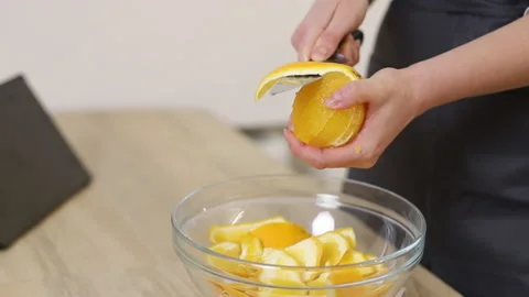 A pastry chef in apron cuts oranges in a bright kitchen. Stock Footage 231238506