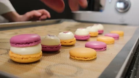 The pastry chef assembles colored macarons with cream. Stock Footage 148943896