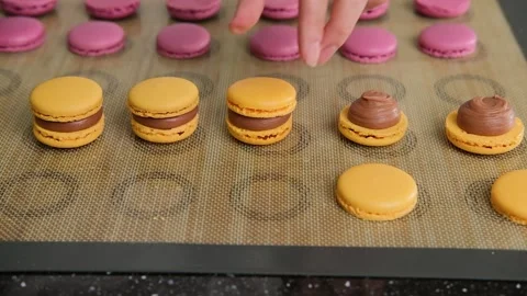 The pastry chef assembles macarons with chocolate cream. Stock Footage 148943690