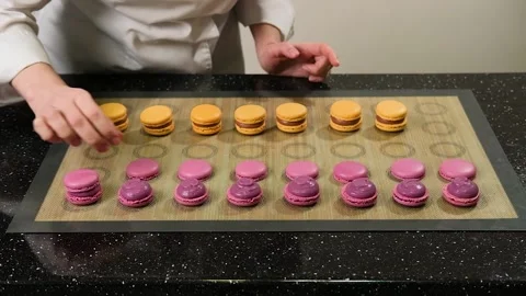 The pastry chef assembles macarons with strawberry cream. Stock Footage 149185189