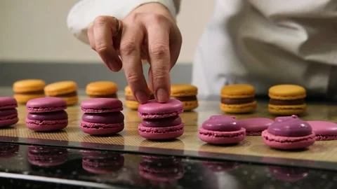 The pastry chef assembles macarons with strawberry cream. Stock Footage 149595490