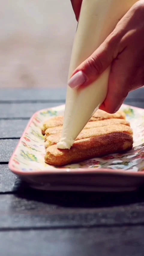Pastry chef assembling a gourmet tiramisu dessert on a summer terrace Stock Footage 341578764