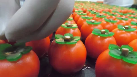 Pastry Chef Assembling Realistic Persimmon-Shaped Mirror Glaze Cakes Stock Footage 345292240