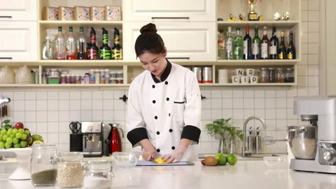 Pastry chef baker hands in gloves slicing dicing a fresh ripe mango on chopping 库存影片 339206096