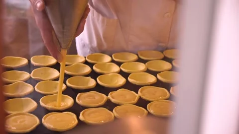 Pastry chef behind the counter makes and fills Portuguese pastel de nata Stock Footage 156512251