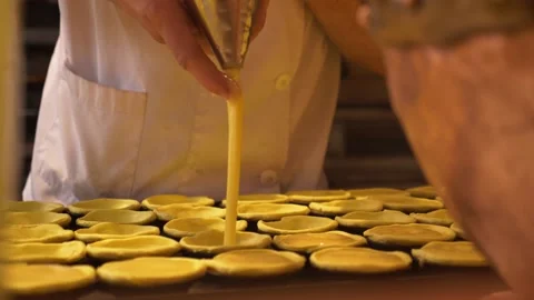 Pastry chef behind the counter makes and fills Portuguese pastel de nata Stock Footage 156512254
