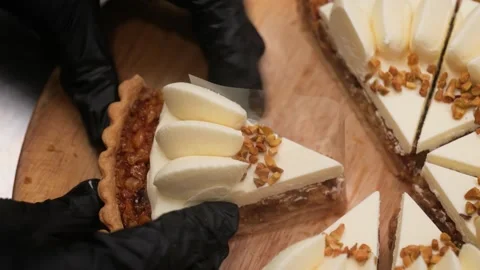 Pastry Chef in Black Gloves Slicing Gourmet Caramel Nut Tart with Cream and Pist Stock Footage 337751547