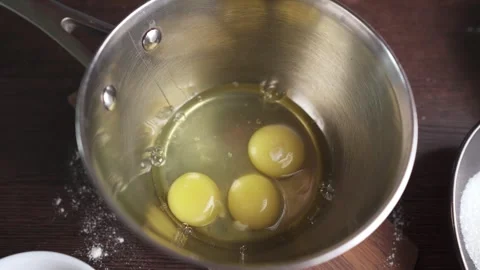 The pastry chef breaks eggs to beat them with sugar to make a biscuit Stock Footage 278440024
