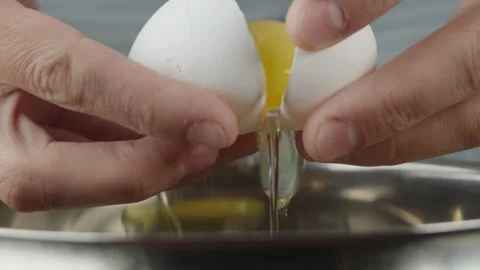 Pastry chef breaks eggs into dishes to beat them with sugar to make a biscuit Stock Footage 286306420