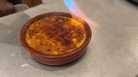 Pastry chef caramelizing sugar on a crème brûlée dessert Stock Footage 335265354