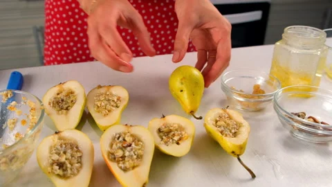 Pastry chef connects halves pears with nuts filling cooking dessert on kitchen. Video stock 313038639