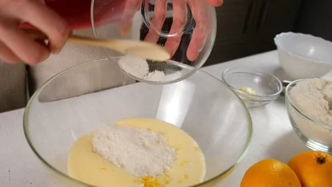 Pastry chef cooking adding sugar to bowl with eggs and creamy orange zest. Video stock 317233491