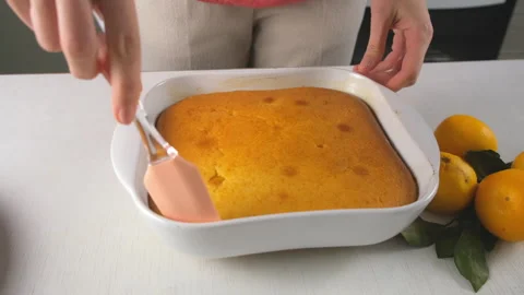 Pastry chef cooking separating tangerine biscuit cake pie from baking pan. Stock Footage 317235560