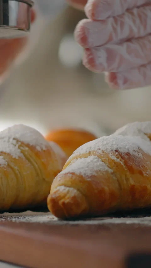 Pastry chef in culinary department dusts fresh European baked goods with fin Stock Footage 338200933