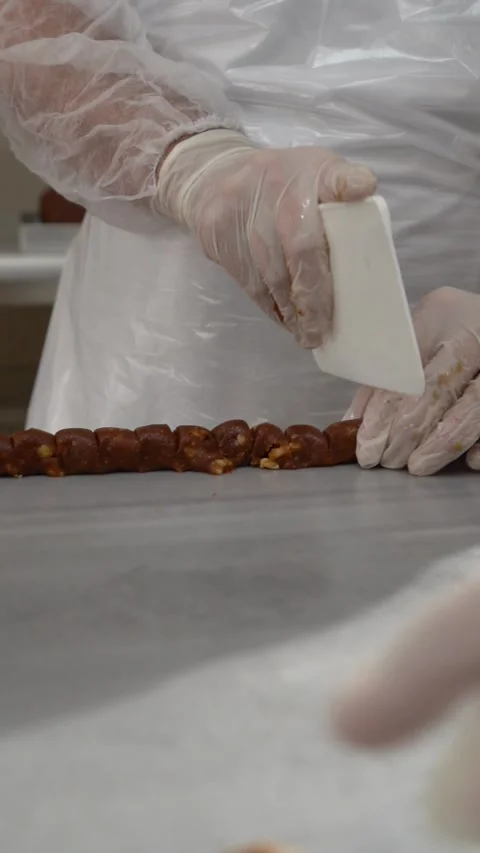The pastry chef is cutting the date and walnut paste Stock Footage 310948013
