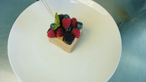 Pastry chef decorates a cake with berries and mint Stock Footage 112978105