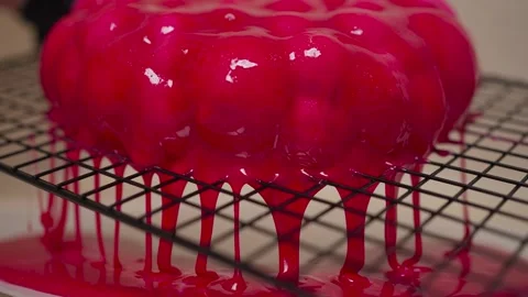 The pastry chef decorates the cake with a mirror pink glaze that flows down the Stock Footage 264033439