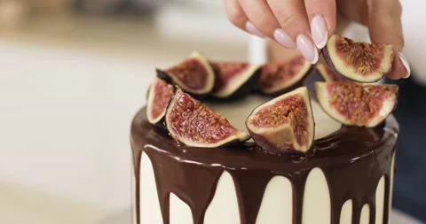 The pastry chef decorates a caramel cake or cheesecake with figs. Close-up. Stockbeeldmateriaal 166461183