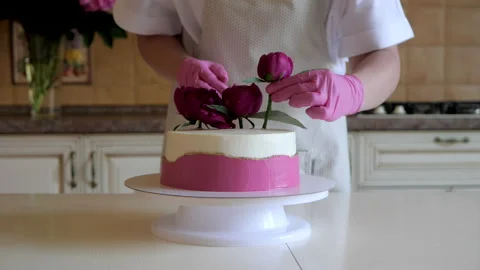 Pastry chef decorates festive cake with fresh flowers of red peonies Stock Footage 135608947